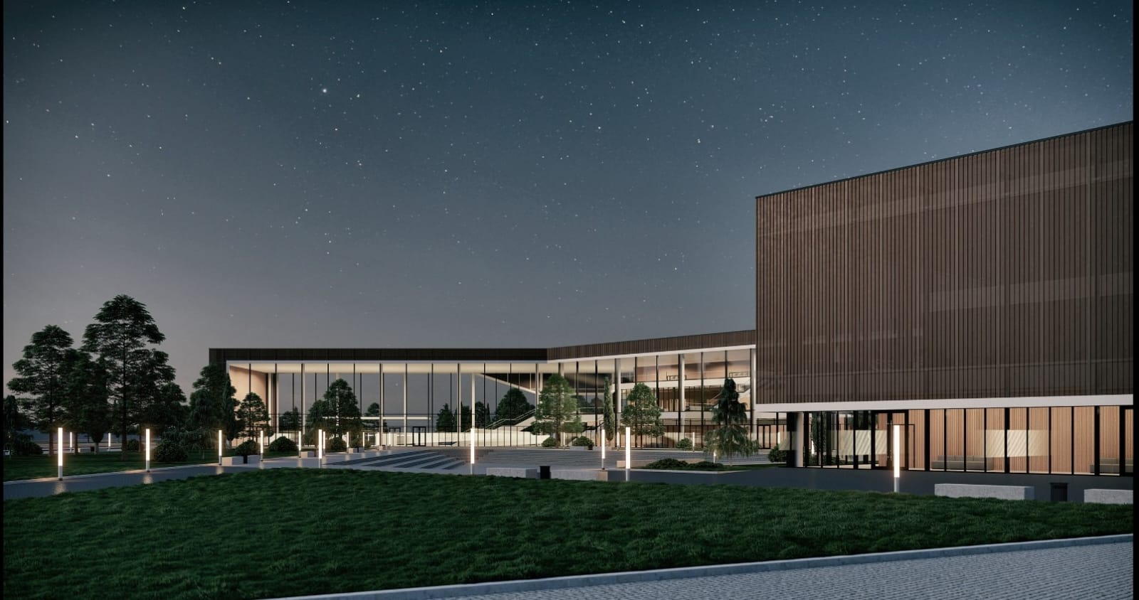 Vista nocturna del campus mostrando la iluminación interior a través de los ventanales