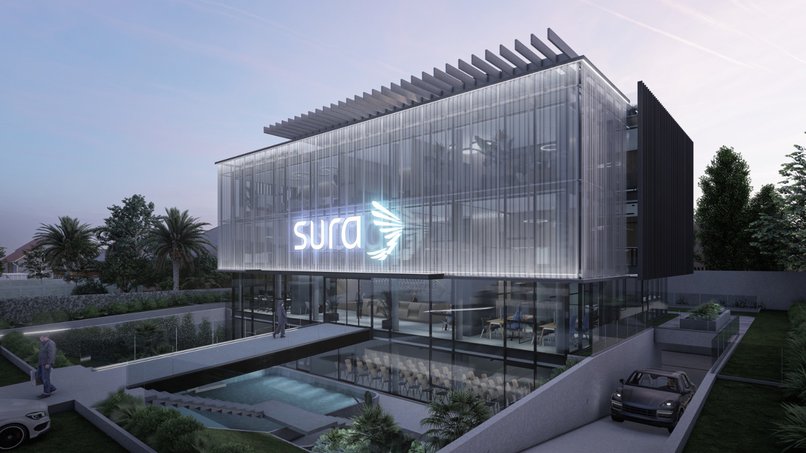Vista nocturna del edificio corporativo con fachada de vidrio iluminada mostrando el logo de SURA